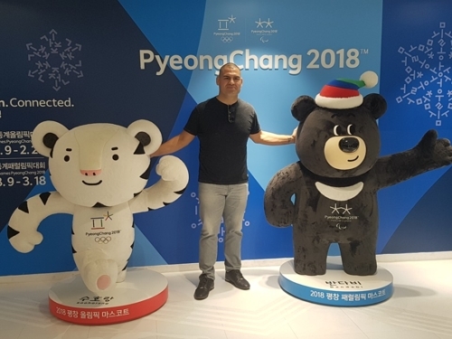 Former Ultimate Fighting Championship (UFC) heavyweight champion Cain Velasquez poses for a photo with the mascots of the 2018 PyeongChang Winter Olympic and Paralympic Games at the Korea Tourism Organization in Seoul on Oct. 20, 2017. (Yonhap)