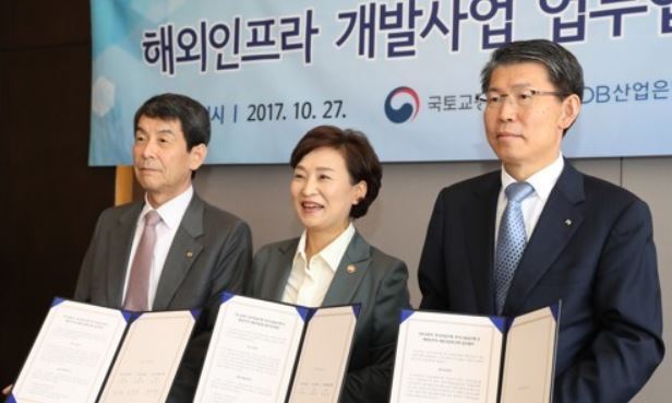 Kim Hyun-mee, minister of land, infrastructure and transportation (C), signs a memorandum of understanding with Lee Dong-gull (L), the chief of the Korea Development Bank, and Eun Sung-soo (R), the head of the Export-Import Bank of Korea, to create a global infrastructure development fund worth 85 billion won ($75.2 million) in a ceremony held in Seoul on Oct. 27, 2017, in this photo provided by the ministry. (Yonhap)
