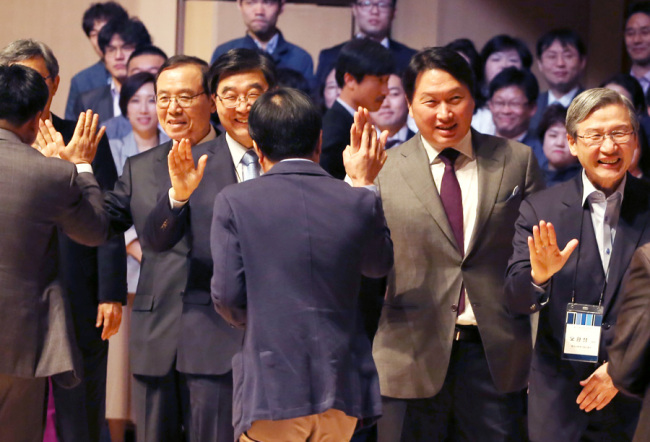 SK Group Chairman Chey Tae-won (second from right) high-fives participants at a Social Progress credti award ceremoney at Yonsei University in Seoul on April 20. SK