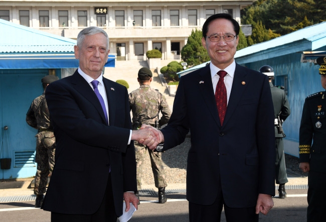 US Defense Minister James Mattis (left) and South Korean Defense Minister Song Young-moo shake hands at the Joint Security Area on the Demilitarized Zone in the border village of Panmunjom in Paju, Gyeonggi Province, Friday. Yonhap