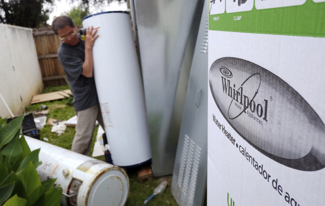 In this Sunday, March 22, 2015, file photo, a repairman installs a Whirlpool water heater at a home in Los Angeles. (AP-Yonhap)