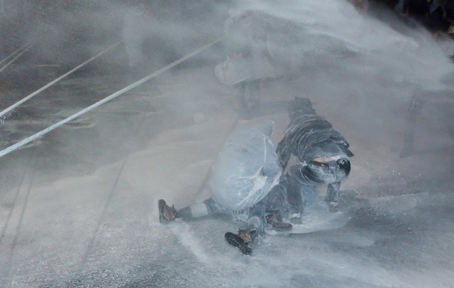 CCTV footage shows activist farmer Baek Nam-gi on the ground after being knocked down by a police water blast on Nov. 14, 2015. Two other activists try to shield him as the blast continues to strike them at the anti-government rally held in central Seoul. Yonhap