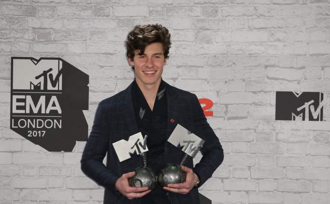 Canadian singer-songwriter Shawn Mendes poses with two of his three awards for best song for `There`s Nothing Holdin` Me Back`, best artist and biggest fans in the winners` area during the 2017 MTV Europe Music Awards at Wembley Arena in London on Sunday. (Yonhap)