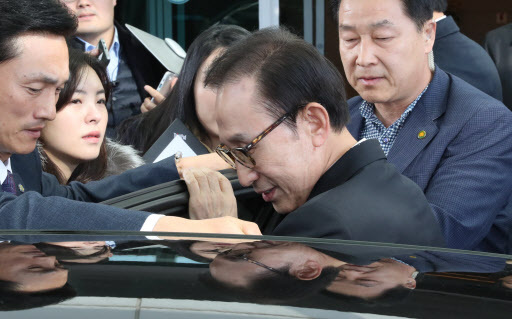 Former President Lee Myung-bak enters a vehicle at the Incheon Airport after arriving in the country from Bahrain on Wednesday. (Yonhap)