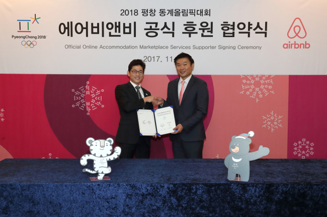 Uhm Chan-wang, director of the PyeongChang Organizing Committee for the 2018 Olympic and Paralympic Winter Games, and Lee Sang-hyun, Airbnb’s head of public policy for Korea, take part in a signing ceremony. (Airbnb)