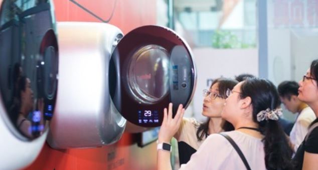 People examine a mini washing machine in this photo provided by Dongbu Daewoo Electronics. (Yonhap)