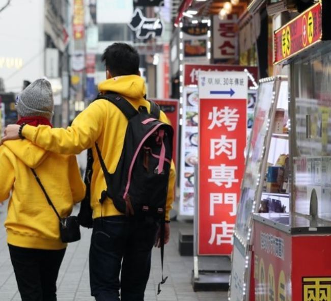 Foreign tourists walk past shops bearing Chinese signs in Seoul`s Myeongdong shopping area, one of the top tourist spots in the South Korean capital, on Nov. 28, 2017. (Yonhap)