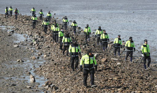 Officials from Incheon Metropolitan Police Agency on Monday morning search the coastal area of Ongjin County, Incheon, for two missing persons from a fishing tour boat that capsized Sunday after colliding with another vessel nearby. (Yonhap)