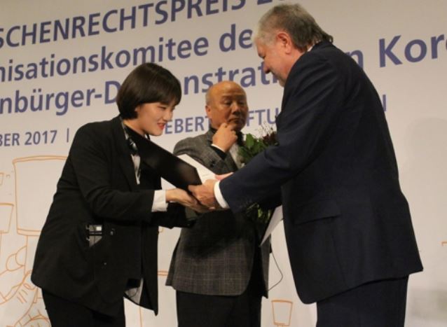 Jang Ae-jin (L), a survivor of the 2014 Sewol ferry sinking, receives the 2017 FES Human Rights Award from Kurt Beck, head of the German political foundation Friedrich-Ebert-Stiftung (FES), during a ceremony in Berlin on Dec. 5, 2017. Jang received the award on behalf of South Koreans who took part in candlelight rallies last year to call for then-President Park Geun-hye`s resignation over an influence-peddling scandal. (Yonhap)
