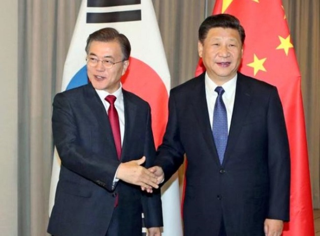Chinese President Xi Jinping, right, shakes hands with South Korean President Moon Jae-in on Thursday in Berlin. (Yonhap)