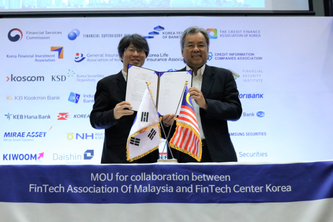 Jung Yoo-shin (left), Chairman of the Fintech Center Korea and David Fong, head of Fintech Association of Malaysia, pose at the ceremony to celebrate the partnership between the two entities. (The Fintech Center Korea)