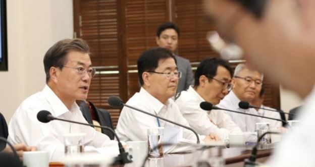 President Moon Jae-in (L) speaks at a weekly meeting with his top aides at Cheong Wa Dae on Oct. 16, 2017. Moon reiterated the need to reduce the country`s working hours, noting that long hours not only reduce people`s quality of life but also cause unnecessary accidents. (Yonhap)