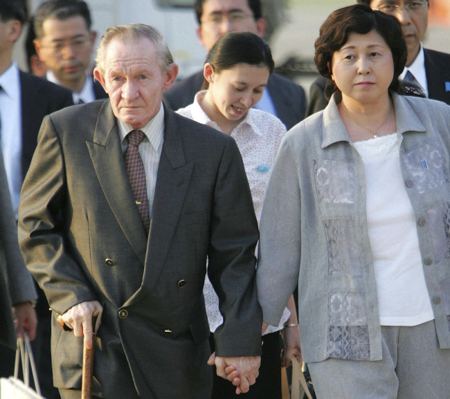 In this July 18, 2004 file photo, former U.S. Army deserter to North Korea, Charles Jenkins, left, escorted by his wife Hitomi Soga, right, and their daughter Mika, center, arrives at Tokyo`s Haneda International Airport. Jenkins, who married Soga, a Japanese abductee and lived in Japan after their release in the 2000s, has died. He was 77.(AP-Yonhap)