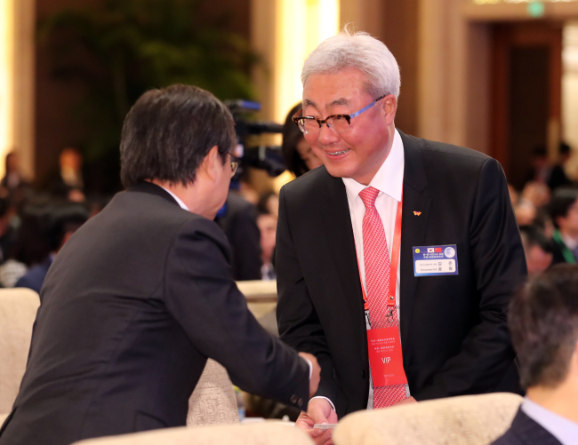 SK Innovation CEO Kim Jun (right) shakes hands with participants during the Korea-China business forum held in Beijing, China, Wedensday. (Yonhap)