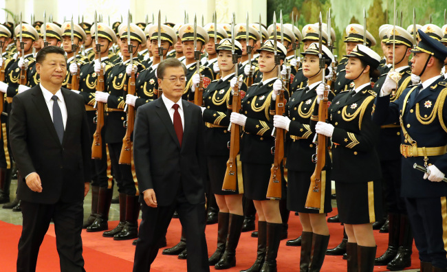 President Moon Jae-in and Chinese President Xi Jinping inspect an honor guard in Beijing. (Yonhap)