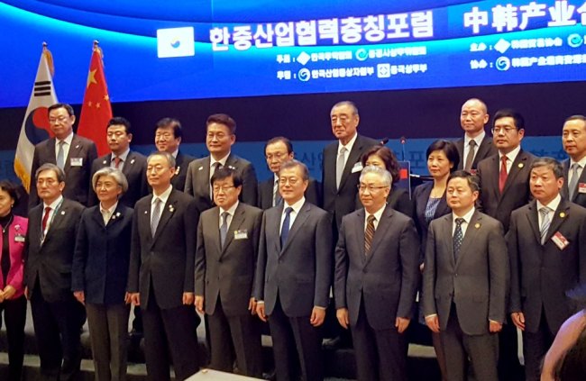 President Moon Jae-in (fourth from right) poses with participants including KITA Chairman Kim Young-joo (fifth from right) during a business forum held in Chongqing, China, Saturday. (KITA)