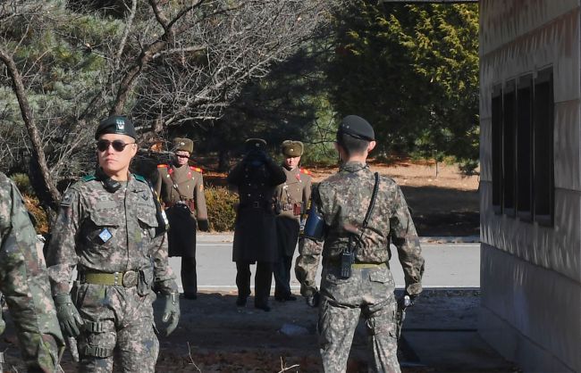 This file photo taken on November 27, 2017 shows North Korean soldiers staring at South Korean soldiers at the truce village of Panmunjom in the Demilitarized zone (DMZ) dividing the two Koreas. A North Korean soldier defected to the South on December 21, 2017 across the Demilitarized Zone that divides the peninsula, Seoul`s defence ministry said. (AFP-Yonhap)