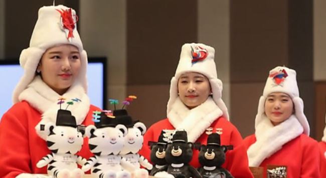 South Korean models wearing costumes for the victory ceremonies at the PyeongChang Winter Olympic and Paralympic Games hold mini dolls of the Olympic and Paralympic Games mascots that will be given to the medalists during the Winter Games at an event in Seoul on Dec. 27, 2017. (Yonhap)