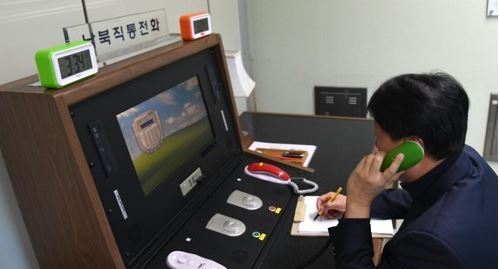 This photo, provided by South Korea`s unification ministry on Jan. 3, 2018, shows a liaison official talking with his North Korean counterpart via the reopened inter-Korean hotline at the truce village of Panmunjom. (Yonhap)