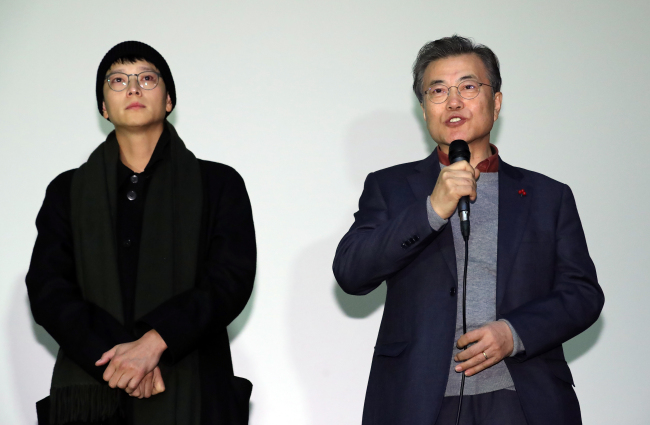 President Moon Jae-in (right) speaks to audiences after watching “1987: When the Day Comes” at a cinema in Seoul on Sunday. Standing on his left is actor Gang Dong-won. (Yonhap)