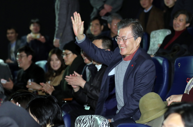 President Moon Jae-in waves at audiences at a screening of “1987: When the Day Comes” at a cinema in Seoul on Sunday. (Yonhap)