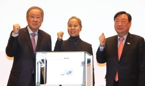 Poongsan Group Chairman Ryu Jin, singer Insooni and POCOG President Lee Hee-beom (from L to R) pose for photos behind a new deluxe coin set commemorating the 2018 PyeongChang Winer Olympics on Jan. 10, 2018 at Poongsan`s headquarters in central Seoul. The set is priced at 11 million won and will go on preorder starting Jan. 15, 2018. (Yonhap)