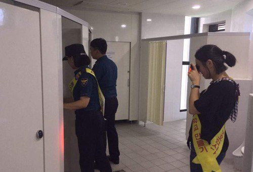 Female inspectors search through washrooms for hidden cameras. (Yonhap)