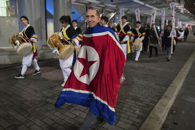 Draped in a North Korean flag, Peter Wilson, of New Zealand, marches with protesters outside the site of a summit on North Korea being hosted by Canada and the U.S., in Vancouver, British Columbia Monday. (AP)