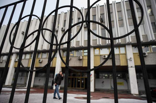 This file photo taken on December 12, 2017 shows a man talking on the phone in front of the headquarters of the Russian Olympic Committee in Moscow. A sports court in Lausanne on February 1, 2018 lifted life suspensions of 28 Russians athletes accused of doping. (AFP-Yonhap)