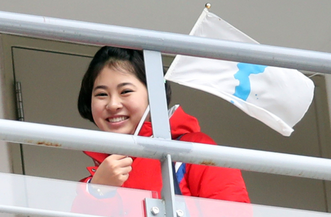 A member of North Korea's cheerleading squad waves a unified Korea flag in PyeongChang. (Yonhap)