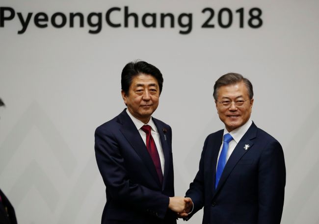South Korea's President Moon Jae-in (right) shakes hands with Japan's Prime Minister Shinzo Abe during their meeting in Pyeongchang on Feb. 9, ahead of the opening ceremony for the Pyeongchang 2018 Winter Olympic Games. (Joint Press Corps. via Yonhap)