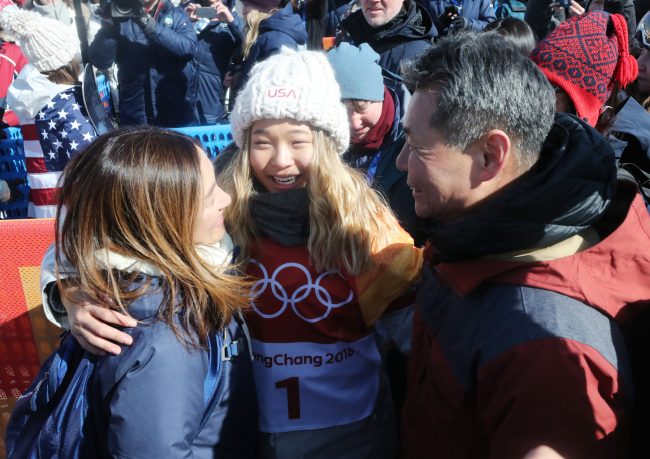 Korean-American snowboarder Chloe Kim hugs her parents after winning the gold medal in the women`s halfpipe of the PyeongChang Winter Olympic Games at Phoenix Snow Park in PyeongChang, Gangwon Province, on Tuesday. (Yonhap)