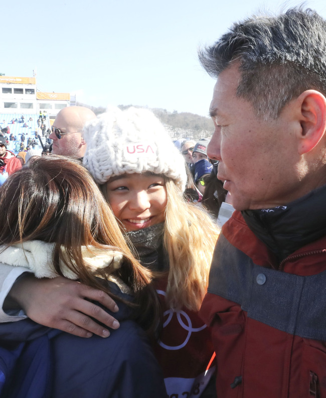 US snowboarder Chloe Kim (C) hugs her mother as her father, Kim Jong-jin (R), stands next to her after she won the gold medal in the women`s halfpipe at the PyeongChang Olympics at Phoenix Snow Park in PyeongChang, Gangwon Province, on Feb. 13, 2018. (Yonhap)