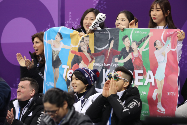 South Korean figure skater Kam Kang-chan (bottom R) cheers wearing a pair of Olympic rings-shaped sunglasses. (Yonhap)