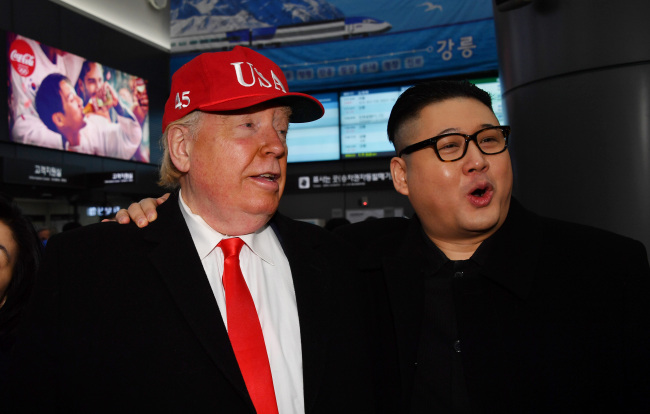 Tourists impersonating US President Donald Trump and North Korea’s leader Kim Jong-un pose for a photo at a train station for PyeongChang Winter Olympics. Yonhap