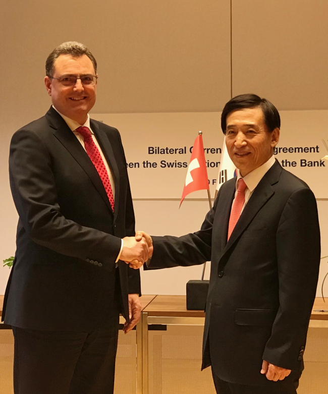 Bank of Korea Gov. Lee Ju-yeol (right) poses with Thomas Jordan, chairman of the Swiss National Bank`s governing board, after signing a bilateral currency swap deal in SNB headquarters in Zurich, Switzerland, Tuesday, in this photo provided by the BOK. (Yonhap)