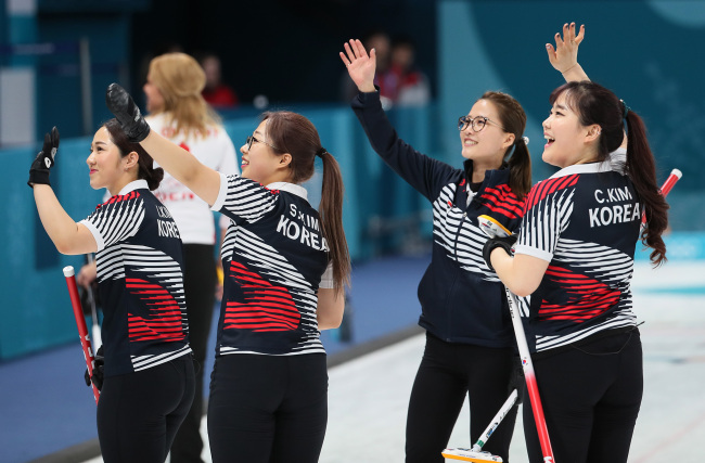 Members of the South Korean women`s curling team wave to spectators after defeating Denmark in a round-robin match held on Wednesday. (Yonhap)