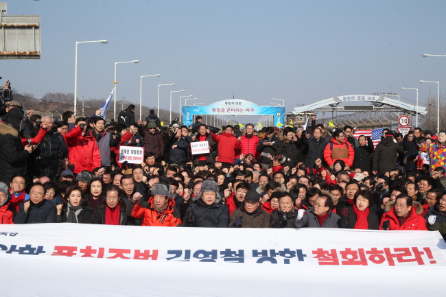 Lawmakers with the main opposition Liberty Korea Party and conservative activists stage a sit-in against a North Korean delegation`s visit on Sunday, in front of the Tongil Bridge. (Yonhap)