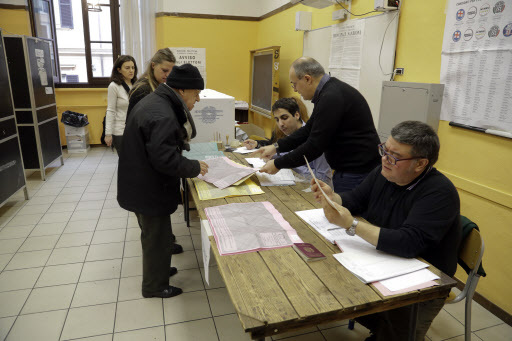 Italians cast votes at a polling station in the general election, Sunday. (AFP)
