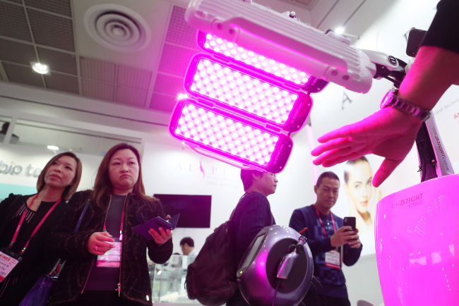 Visitors check out a skin regeneration device developed by Korean medical device maker Grand Aespio during KIMES 2018 (Yonhap)