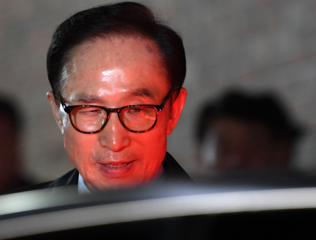 Former President Lee Myung-bak boards a vehicle as he was taken into custody on Friday. Yonhap