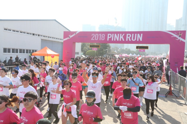 Participants of Pink Run, a marathon event held by Amorepacific, pass the starting line in Busan on Sunday. (Amorepacific)