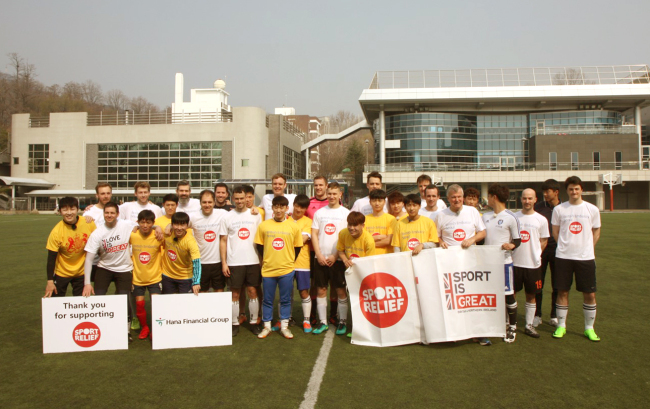 British Embassy staff (in white uniforms) pose with North Korea defectors (in yellow) before a friendly soccer game Saturday at Seoul Foreign School. (British Embassy).