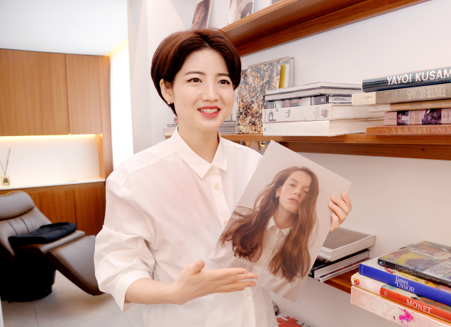 Cha Hong explains hair style trends for the 2018 spring-summer season, holding the brand’s seasonal look book. (Park Hyun-koo/The Korea Herald)