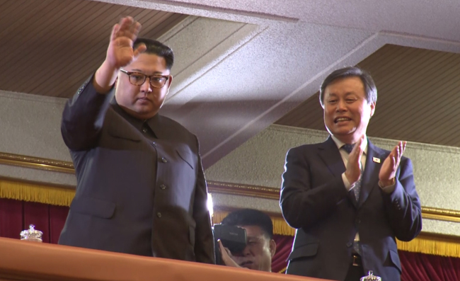 North Korean leader Kim Jong-un (left) waves and South Korean Culture Minister Do Jong-whan claps before a South Korean art troupe performs in Pyongyang, in this image captured from pool footage taken on April 1, 2018. (Yonhap)