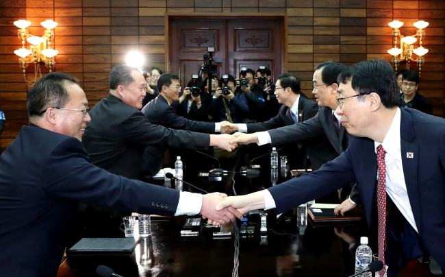 South Korean delegation, led by Unification Minister Cho Myoung-gyon (right) and North`s delegation, led by Ri Son-gwon, shake hands after agreeing to inter-Korean summit on March 29. Yonhap