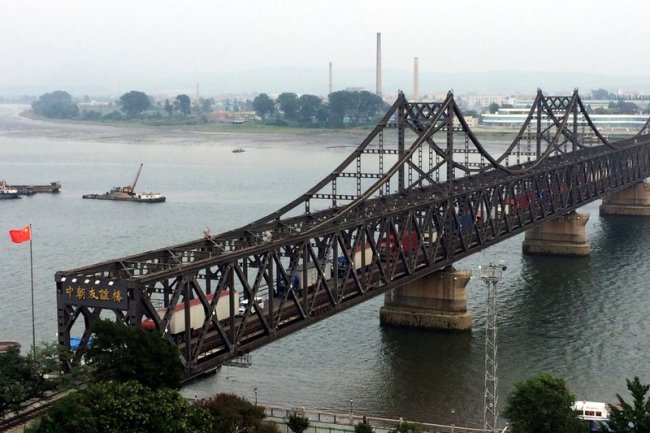 In this Sept. 4, 2017, file photo, trucks cross the friendship bridge connecting China and North Korea in the Chinese border town of Dandong, opposite side of the North Korean town of Sinuiju. (AP-Yonhap)