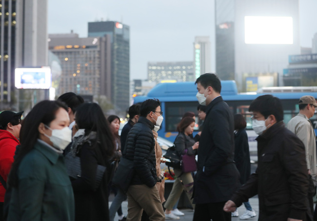 Citizens wearing masks cross roads near Gwanghwamun Square in Seoul on Friday. (Yonhap)