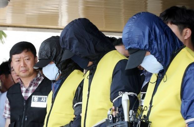 Covering themselves with caps and masks, the three suspects in a gang rape of a school teacher stand in front of media at a police station in Mokpo, South Jeolla Province, on June 10, 2016, before being transferred to a detention center. (Yonhap)