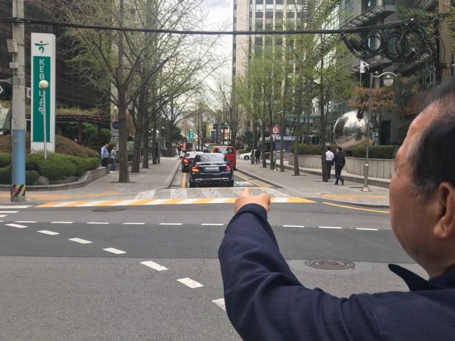 Head of the management office of Kyunghee Palace’s Morning, one of apartment complexes near Gwanghwamun Square, points at one of the streets which he and the area residents claim will suffer severe traffic congestion if Seoul directs the traffic there to make Gwanghwamun Square more pedestrian-friendly.